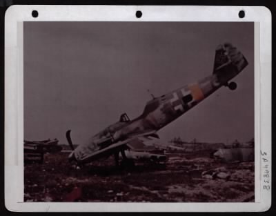 Thumbnail for ␀ > Side View Of A Me-109 Tossed On Its Nose By U.S. Air Force Bombs.  In The Background Are Poles Camouflaged To Resemble Trees, At The Messerschmitt Aircraft Factory In Augsburg, Germany.