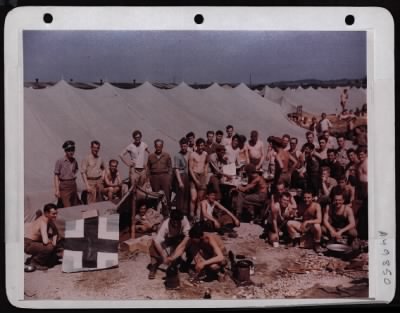 Thumbnail for ␀ > Moosburg, Germany Prisoner Of War Camp.  The Boys Borrowed This Table For Mess Purposes After Being Freed.  In The Rear Is A Tent Which Housed Two Hundred Of Them.