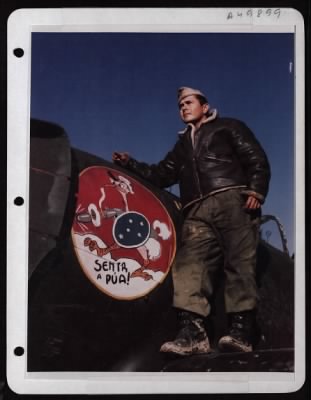 Thumbnail for ␀ > M/Sgt. Robson Saldanha Poses Beside The Bird Insignia Of The First Brazilian Fighter Squadron Painted On A P-47 Thunderbolt.