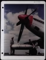 Crew Chiefs Placing Auxiliary Fuel Tank Under Wing Of A P-51 - Page 1