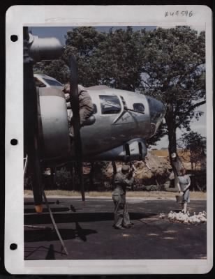 ␀ > Msgt. J.P. Wellmaker Cleans 50 Cal. Guns On A Boeing B-17 As An English Farm Wife Herds Her Ducks Away From The Plane At A Base In England.