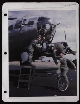 ␀ > Tsgt. Charles A. Barbier Of Wallace, La., Checking Gun Mount Bolt On A B-17, Waves To Msgt. George Grose Of Tallahasse, Fla., As He Rides By On A Unicycle.  England.