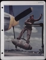 Cpl. Lloyd Shumway Directs Crane With A 500 Lb. Bomb Into Place On The Wing Of A North American P-51 At A Base In England. - Page 1