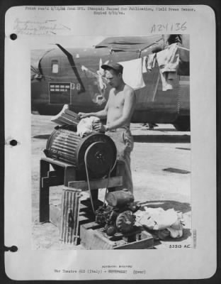 Consolidated > Sgt. John H. Dowell, 1255 Page St., Bristol, Va., is a propeller specialist with a Consolidated B-24 Liberator Bomb Group in the 15th Air Force, Italy. In his spare time he invented this washing machine. This picture shows the Sgt. At work with the