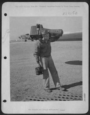 Thumbnail for Consolidated > ITALY-Sgt Ryder carries "Annie," large 24-inch camera to the plane in which he will fly the days mission. In his right hand is a K-20 type camera, used for "shooting" any unusual pictures for news release.