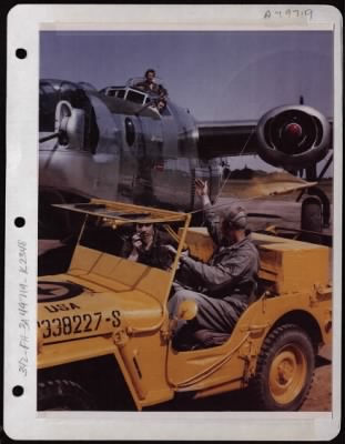 Thumbnail for NAGA Head Hunters > Control Jeep Manned By Cpl Larry Roth Of Brooklyn New York And Cpl Wallace Merquardt Of Fremont Wisconsin, Directs A Consolidated B-24 To The Runway For Take-Off At A Base In England.