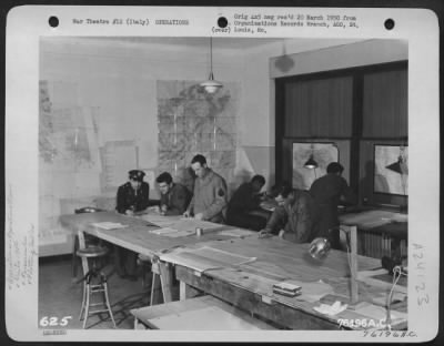 Consolidated > Capt. Paradise (Extreme Left) Confers With Personnel Of The 90Th Photo Reconn Wing In The Plotting Room At An Air Base In Foggia, Italy.