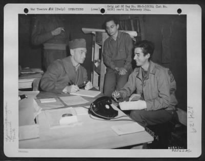 Consolidated > Lt. Eldon H. Dahl (Right) Of Bozeman, Mt, A Member Of The 416Th Bomb Squadron, 99Th Bomb Group At Caserta, Italy, Is Interrogated By Lt. Colonel Arthur E. Sutherland After His Return To His Base From A Mission.  Lt. Dahl'S Plane Was Shot Down Behind Enemy