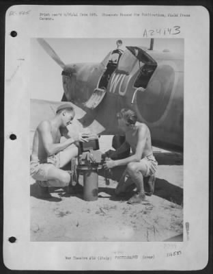 Consolidated > These Two British Ground Crew Men Change The Magazine Of An Aerial Camera That Will Be Placed In The Fuselage Of A Spitfire That  'Spies' On Enemy Activity From The Air.  Italy