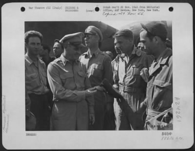 Consolidated > Major General Nathan F. Twining, Commanding General Of The 15Th Air Force (Second From Left) Examines A Cap Brought Back By One Of The 1000 Air Force Combat Crewmen, Recently Evacuated From Rumanian Prison Camps And Brought To A 15Th Air Force Base In Ita