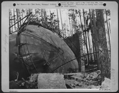 Consolidated > One Of The Many Huge Luftwaffe Oil Storage Tanks, At Bad Berka, Germany, Tipped Over Heavily On Its Side, And The Protective Brick Side Wall Partially Demolished.  A Direct Bomb Hit Caused The Tip Over.