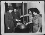 At Early Morning Mess Cpl. Hamblin And Pvt. Ida Mae Christie Serve Generous Portions To Pvt. Martha G. Eicher Of Rocky River, Ohio.  Behind Pvt. Eicher Are Cpl. Doris M. Hensler Of Minneapolis, Mn, And Other Wacs Who Work At The 12Th Air Force Headquarter - Page 1