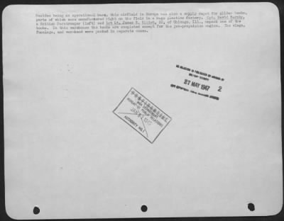 Thumbnail for Consolidated > Besides being an operational base, this airfield in Europe was also a supply depot for glider bombs, parts of which were manufactured right on the field in a huge plastics factory. Cpt. David Barnby, a British Paratrooper (left) and 1st Lt. James E.
