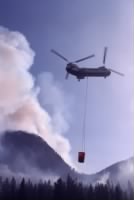 Helicopter using a river water to douse fire