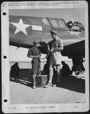 General > Sgt. John N. Rumen, Racine, Wisc., right and Sgt. Liang Chow, left, look over a belt of 50 cal. Ammunition before loading the plane's guns. These two men worked with the American Volunteer Group (popularly knows as the "Flying Tigers") before the AVG