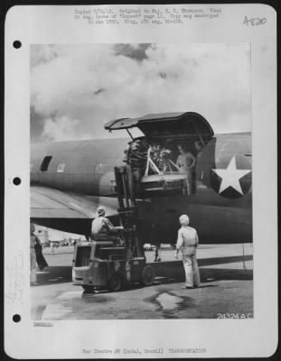 General > An engine is placed on board a freight transport bound west, for overhaul.  Natal, Brazil.