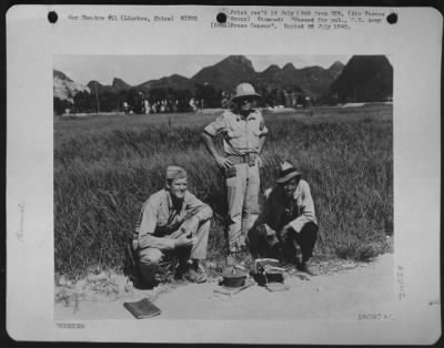 Mines > Lt. Colonel Wright Hiatt, Winchester, Indiana, And Capt. Berwyn Fry, 7314 Bennett Ave., Chicago, Ill., Engineers With The 14Th A.F., And A Chinese Worker, With Two Of The Mines Removed From The Air Strip, At Liuchow, China.  The Former 14Th A.F. Base At L