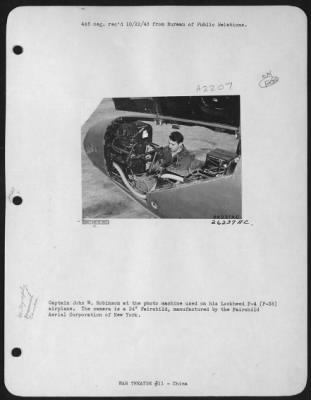 Thumbnail for Cameras > Captain John W. Robinson at the photo machine used on his Lockheed F-4 (P-38) airplane. The camera is a 24" Fairchild, manufactured by the Fairchild Aerial Corporation of New York.