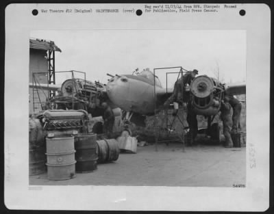 Engines > 9th Air force mechanics pictured at work repairing engines ona P-38 Lightning fighter-bomber somewhere in Belgium. Working under adverse and variable conditions, ground crews and maintenance men are playing an important part in the air offensive