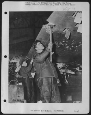 General > Belgium-Ruefully examining part of the flak damage to the Republic P-47 Thunderbolt fighter-bomber "I'll Get By" is S/Sgt. Robert Rakow, Jr., 2116 S. 12th St., Sheboygan, Wis., while Pfc. Charles R. Eck, 511 Arlington Ave., Baltimore, Md., armorer