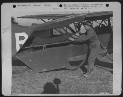 General > BELGIUM--T/Sgt. James E. ofust, 666 Ankney Ave., Somerset, Pa., secures the litter in the rear of his Vultee L-5 before the take-off. He is one of the pilots now evacuating litter cases from the front lines to hospitals at the rear by plane.