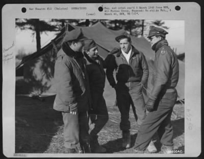 General > BELGIUM--Talking over a mission in front of the captured German tents that are used for Operations and Orderly Room are 2nd Lt. Coleman F. Cody, assistant operations officer, 356 Tappan St., Brookline, Mass.; S/Sgt. Herbert Young, 136, 172nd St.
