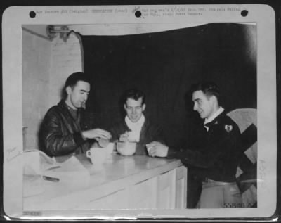 Thumbnail for General > Three Ninth Air force fighter-bomber pilots from Caliofrnia, who shot down five FW-190's among them during, the first day of von Rundstedt's counter offensive, compare notes in the squadron ready room in Belgium. They are, left to right: first man