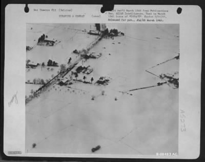 General > This is how a Nazi road convoy (between St. Vith and Schonberg, Belgium) looks to a "dicing" 9th Air force tact recon. pilot. He files right through fire of three AA guns (smoke puffs at right).