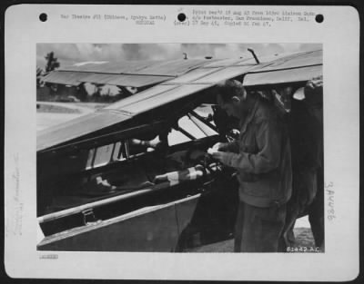 Thumbnail for Evacuation > Flight Surgeon, Capt. Carl B. Smith, Of 163Rd Liaison Squadron, Checks Diagnosis Tag Of Wounded Soldier Prepatory To Transfer Of Wounded Men To Ambulance.  Wounded Man Has Chest Wound And Is Aided In Breathing By Aviator'S Oxygen Mask And Supply Bottle Fa