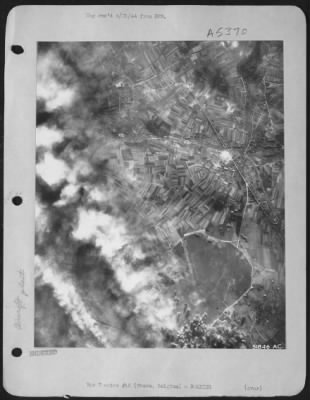 Evere > FIRE SPREADS OVER EVERE--Huge billows of flame and smoke are carried over the town of Evere, near Brussels, after 8th AAF ofrtresses unleashed an attack on the German aircraft engine and plane repair depot there 10 April 44. Incendiaries and high