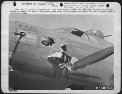 Battle Damage > T/Sgt. Paul R. Taylor, of Randolph Minn., top turret gunner of Boeing B-17 #42-29996, looks out of shattered window, on forward left side of ship. Damage shown caused by 20 mm cannon shell which also cut off oxygen supply on left side of plane.