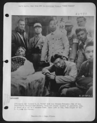 General > Injured U.S. Raider with his Chinese Friends---One of Gen. Doolittle's "Shangri-La" Fliers, (name not known) injured in parachute jump, is shown on a cot in a Chinese home. Rear left is Col. John Hilger of the U.S. Army Air forces.