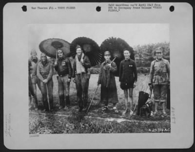 General > FROM AERIAL UMBRELLA TO CHINESE PARASOLS. four members of Maj. Gen. James Doolittle's Raiding Party that dropped bombs on Tokyo April 18, 1942 exchange smiles with Chinese soldiers under picturesque parasols. Photo was taken during interim