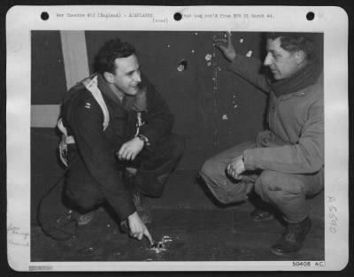 Battle Damage > Capt. Dickerson, of Nashville, Tenn. Squadron leader, and Lt. Soenke, of Davenport Iowa, pilot, shown inspecting the flak sieved tail of a Flying ofrtress on returning from the daylight attack on Nazi airdromes east of Munich.