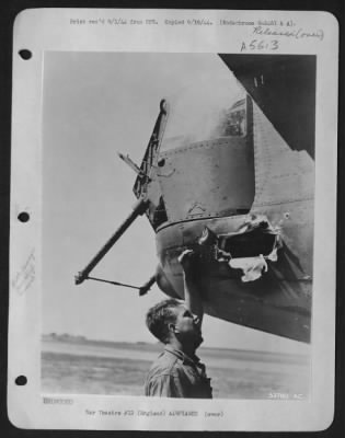 Thumbnail for Battle Damage > ENGLAND-M/Sgt Robert Hinman of Madison, Wisconsin, crew chief of the Liberator "Liberty Lib" inspects the large hole in the tail of the bomber caused by a flak burst.