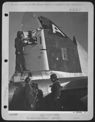 Battle Damage > Pilot, 2nd Lt. John R. Lindahl, New Britain, Conn., holds the crew's mascot, "Torval", after landing the badly damaged ofrtress. The dog was along on the trip as he is with the crew constantly. "Torval" has over 100 hours in the air and was flown to