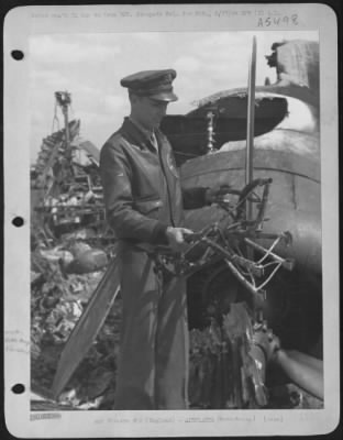 Battle Damage > Capt. Alvin D. Skaggs Of Lawton, Oklahoma, Ponders His Luck As He Holds Charred Remnant Of His Pilot'S Seat From The Smoldering Wreck Of His Ship, The Consolidated B-24 Liberator 'Vadie Raye'.  The Lib Was Set Afire By Enemy Fighter Attacks After The Assa