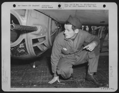 Battle Damage > Sgt. Roger Mcdermott, Detroit, Mich, Ball Turret Gunner In The Boeing B-17 "The Great Speckled Bird" Holds His Breath And Crosses His Fingers As He Looks At The Hole Where A .20 Mm Cannon Shell Entered His Ball Turret, Circled Around Inside And Left Him U