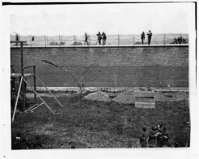 1923 - Washington, D.C. Coffins and open graves ready for the conspirators' bodies at right of scaffold
