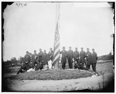 279 - Washington, D.C. Signal Corps officers lowering flag at their camp near Georgetown; Gen Albert J. Myer, in civilian dress, at right of pole