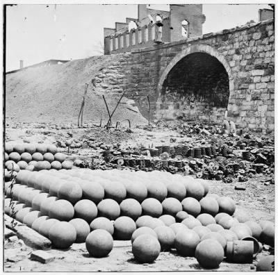 4157 - Richmond, Va. Piles of solid shot, canister, etc., in the Arsenal grounds; Richmond & Petersburg Railroad bridge at right