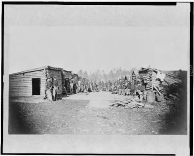 5520 - Union soldiers, in camp, posed in front of log buildings