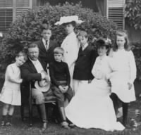 Pres. and Mrs. Theodore Roosevelt seated on lawn, surrounded by their family