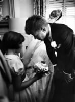 Janet Auchincloss, half sister of bride, talks to Kennedy while bride looks out window.jpg