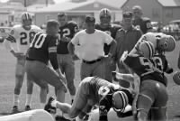 1962_Vince Lombardi, at left center in white T-shirt, watches as center-linebacker Ken Iman  tackles  halfback Roger Holdinsky.jpg