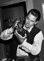 Glenn Ford checks his camera equipment.jpg