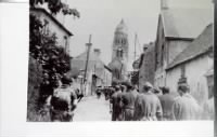 Ste. Marie DuMont, Normandy, FR- marching a few German Supermen through.  Note shell hole in the church steeple..JPG