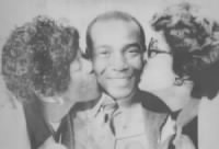 Ernie Banks gets a kiss from his mother Essie (left) and his wife (right).jpg