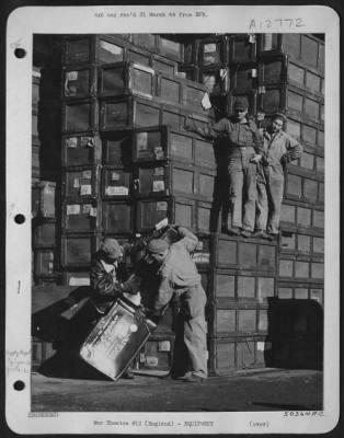 General > Supply men at depot shown uncrating self-sealing fuel tanks. Countless crates are stacked away for immediate use.