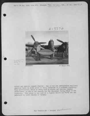 Thumbnail for General > EIGHTH AAF SERVICE COMMAND STATION-One of the new jettisonable auxiliary gasoline tanks is shown prior to being installed on a Lockheed Lightning. This modification, which is being done by Eighth AAF Service Command technicians, is one of the reasons